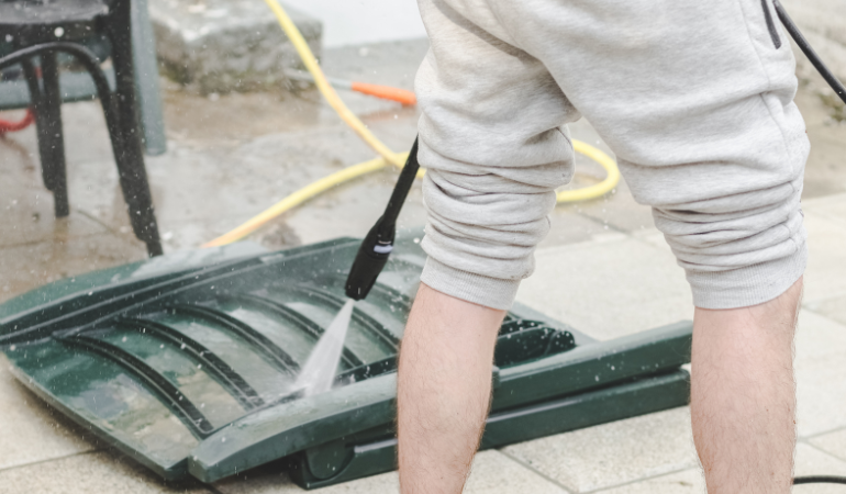 mężczyzna czyszczący ogrodowe meble z tworzywa