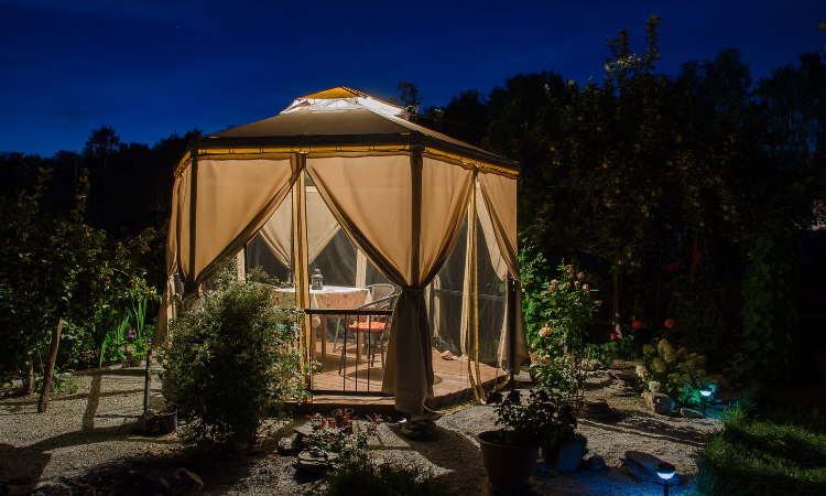 pawilon ogrodowy z wygodnymi meblami ogrodowymi wieczorem 